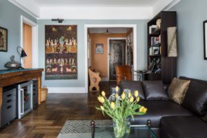 living room with glass coffee table with yellow tulips on it and a leather sofa