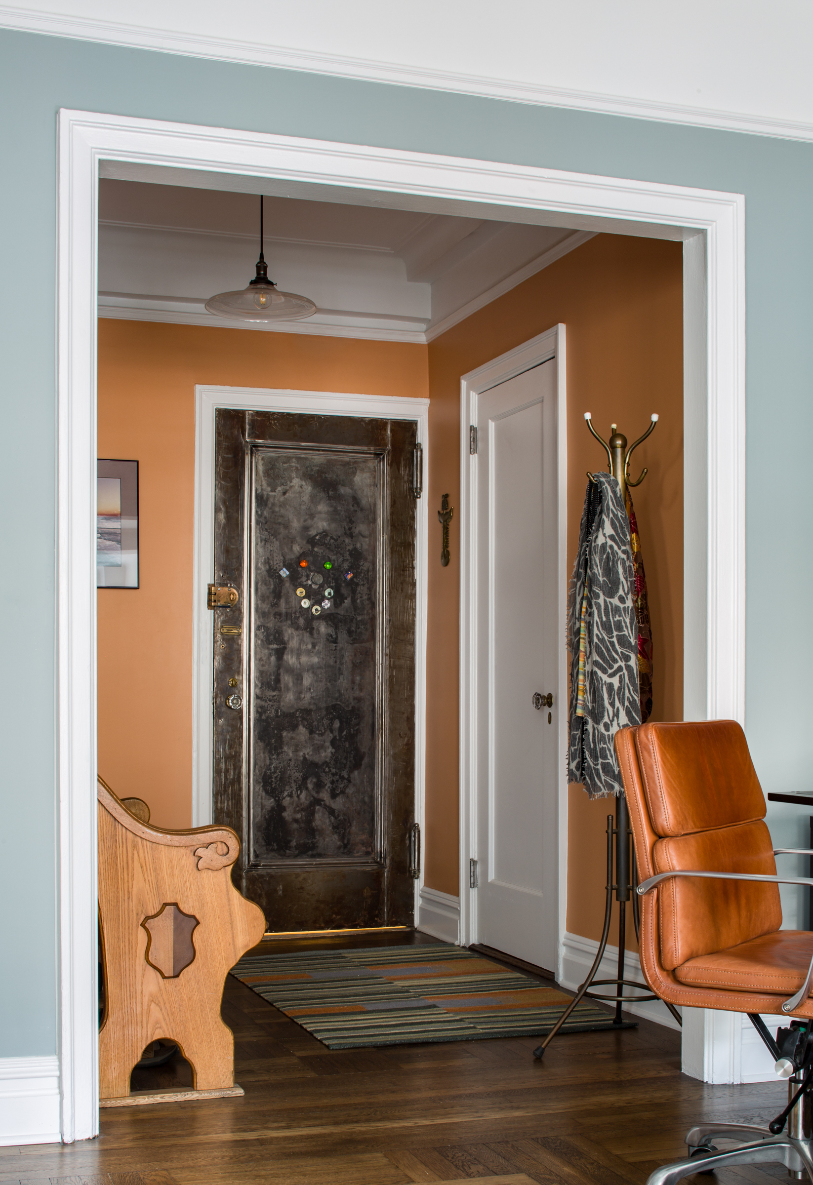 apartment foyer with orange paint and wooden bench