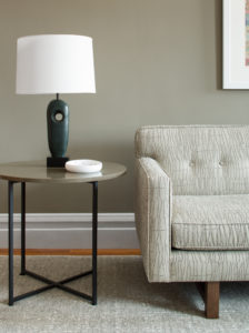 close up of a sofa and end table with a lamp on it