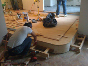 carpenter installing a raised floor with wooden flooring