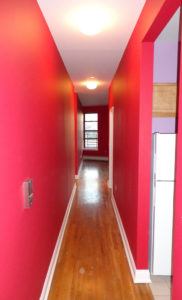 bright red hallway with oak floors and white trim