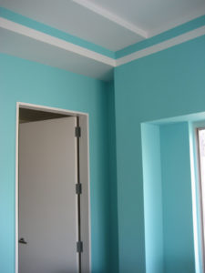 Corner of a bedroom painted bright teal