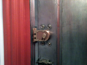 close up detail of a brass deadbolt lock on a metal door