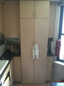 Large pantry cabinet with a dishtowel on the handle