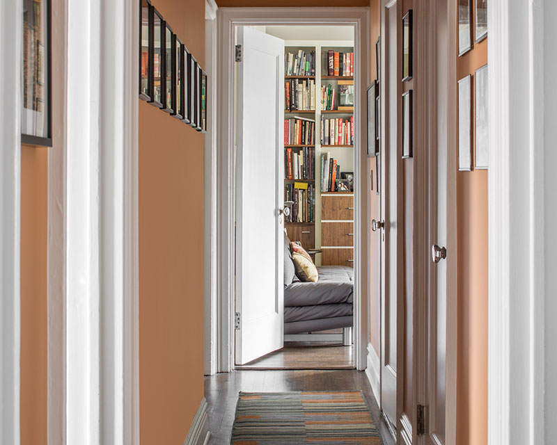 Peach painted hallway with custom trim work by Paint Works NY