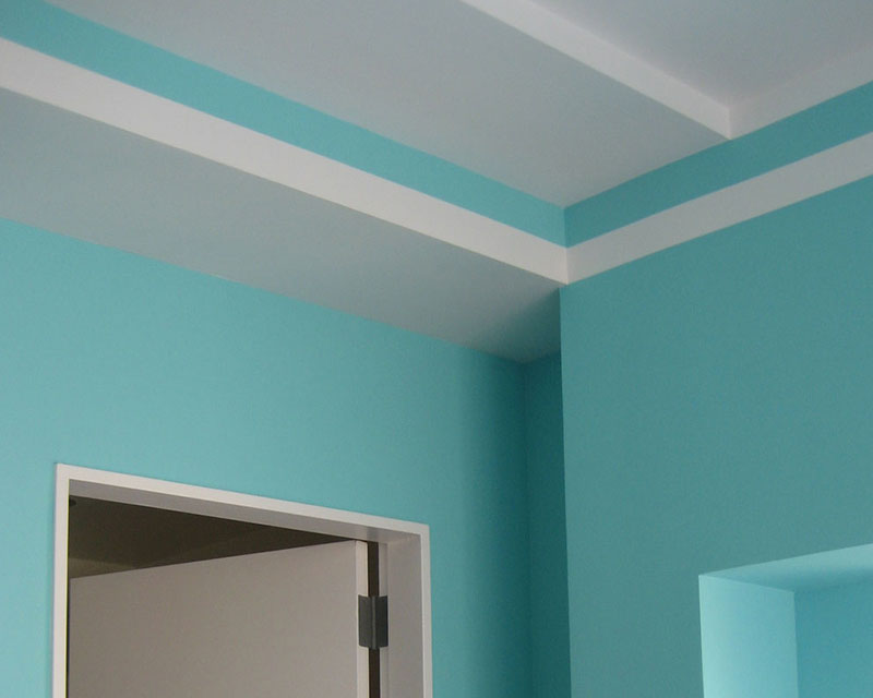Corner of a room painted teal with taped off lines and clean paint job