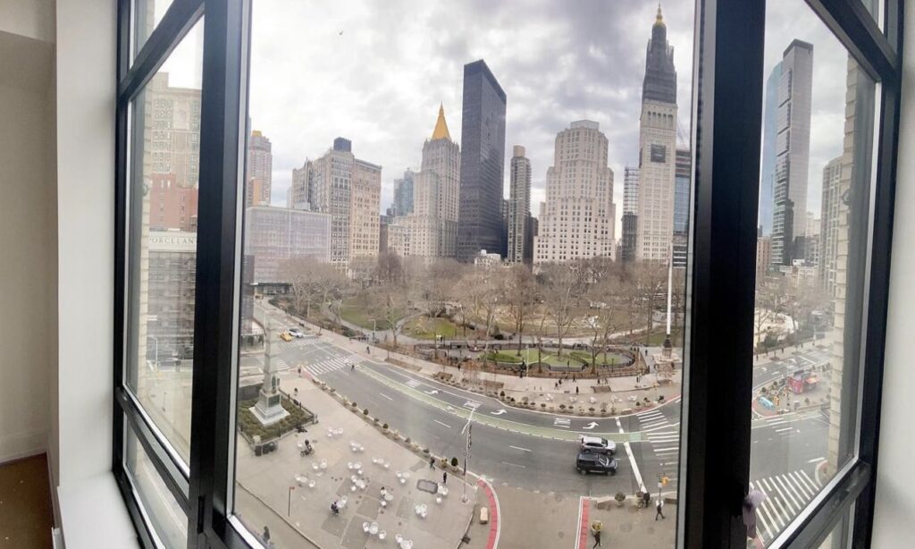 View out the window of an apartment in Manhattan overlooking the NYC skyline