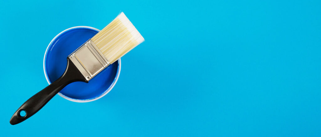Paint can and brush on a blue background