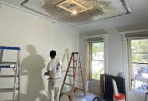 Paint Works New York crew member getting ready to fix a plaster ceiling