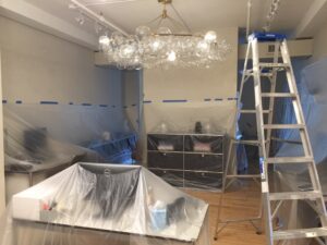 Setup for a commercial painting project with ladders and plastic