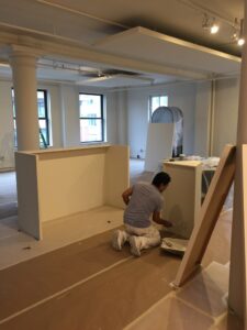 worker painting cabinets on a commercial painting job