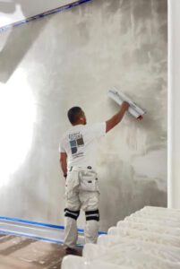 worker preparing a surface for paint