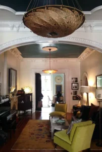 ornate chandelier in an apartment with decorative crown molding and arched doorways