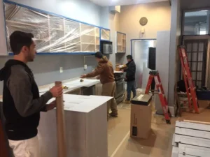 Renovation of a NYC apartment kitchen, cabinets taped off and ready for painting.