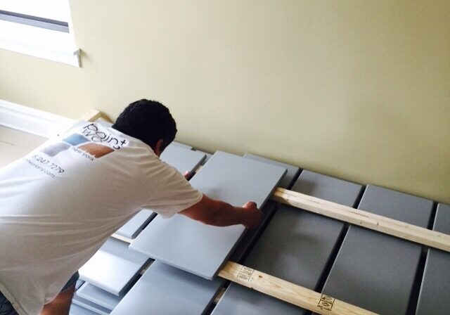 Worker laying out cabinet doors to dry