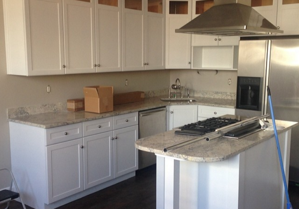 Sprayed white kitchen cabinets with subway tile and granite