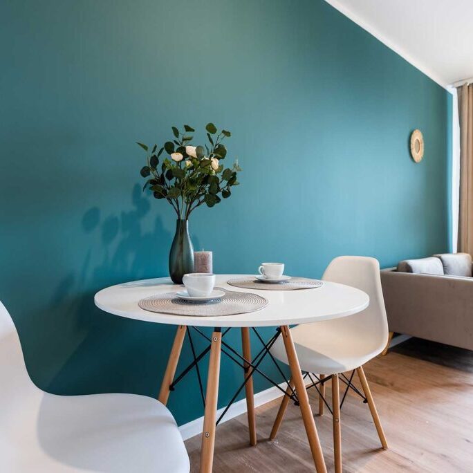 A seating area in an apartment staged for sale with a teal blue wall