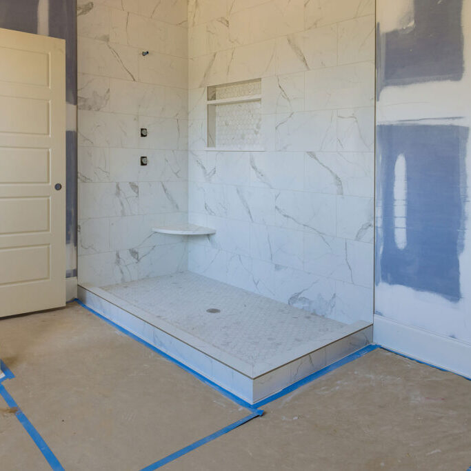 Partially completed bathroom renovation with shower stall